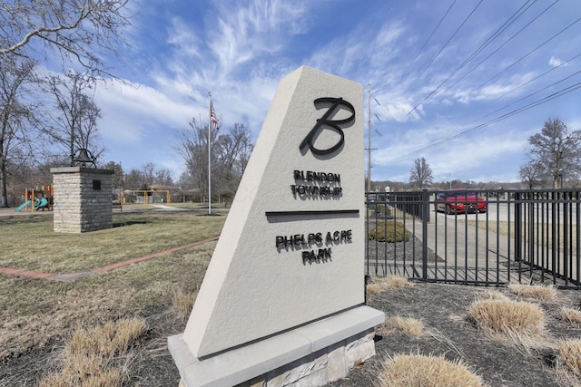 community sign with a lawn and fence