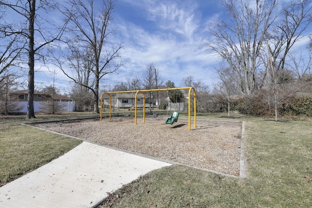 community play area with a lawn and fence