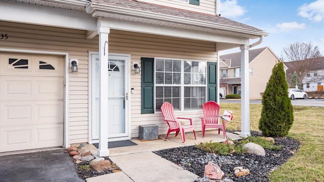 property entrance featuring roof with shingles, covered porch, and an attached garage