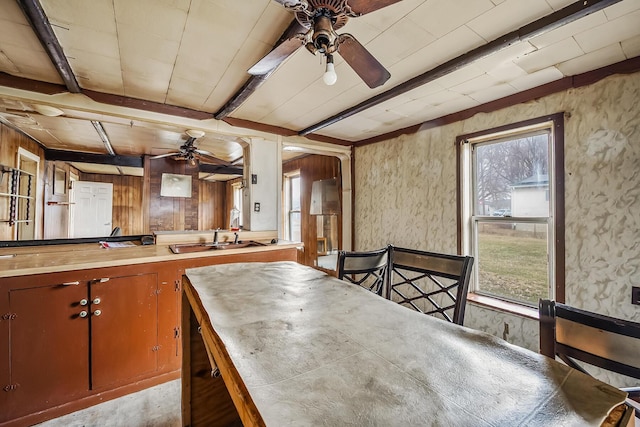 kitchen featuring beamed ceiling, a ceiling fan, and a sink