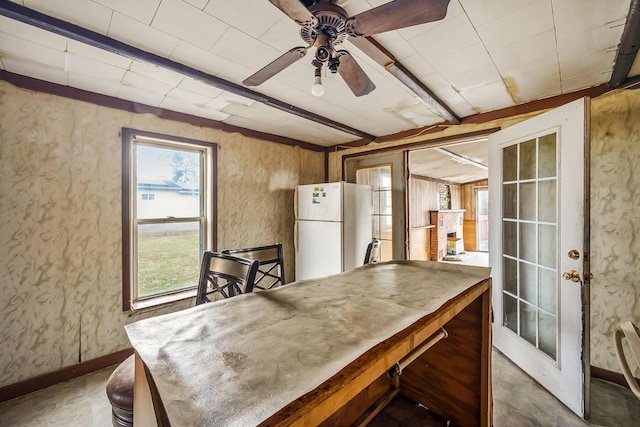 dining area with beamed ceiling, a fireplace, baseboards, and ceiling fan