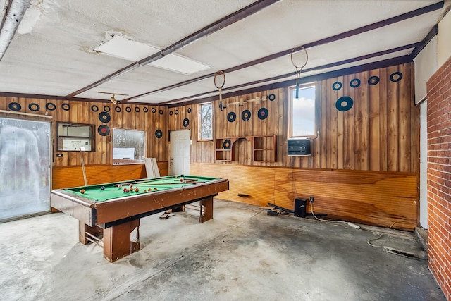 recreation room featuring wooden walls, concrete floors, and billiards