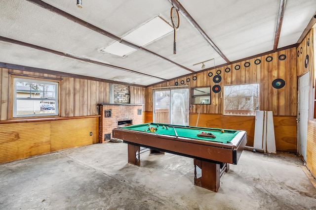 game room with lofted ceiling, concrete floors, wood walls, and a fireplace