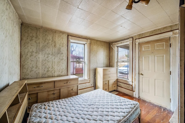 bedroom featuring wallpapered walls and wood finished floors