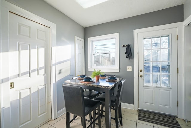 dining space with light tile patterned floors, baseboards, and a wealth of natural light