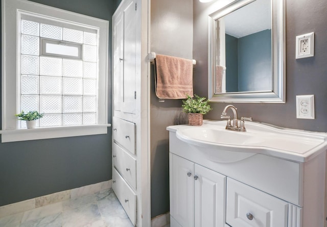 bathroom with vanity, baseboards, and marble finish floor