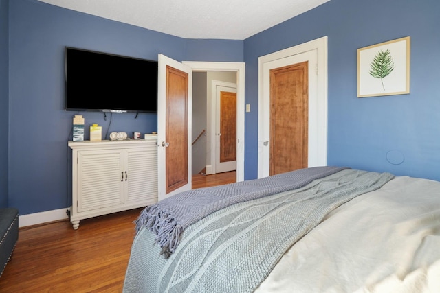 bedroom with wood finished floors and baseboards