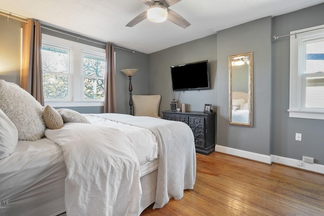 bedroom featuring light wood-type flooring, baseboards, and a ceiling fan