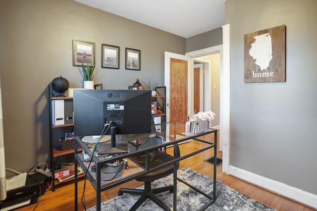 office area featuring visible vents, baseboards, and wood finished floors