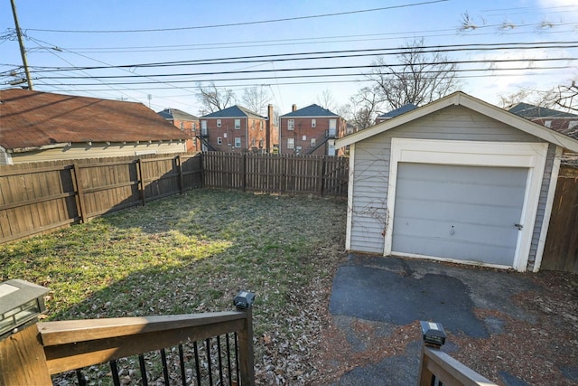 view of yard with a fenced backyard, a detached garage, and an outdoor structure