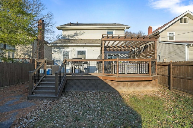 back of house with a deck, a fenced backyard, and a pergola