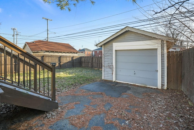 detached garage with fence and driveway