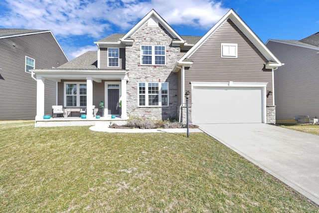 view of front of house with stone siding, covered porch, driveway, and a front lawn