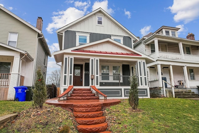 view of front of house featuring a porch, a front yard, and board and batten siding