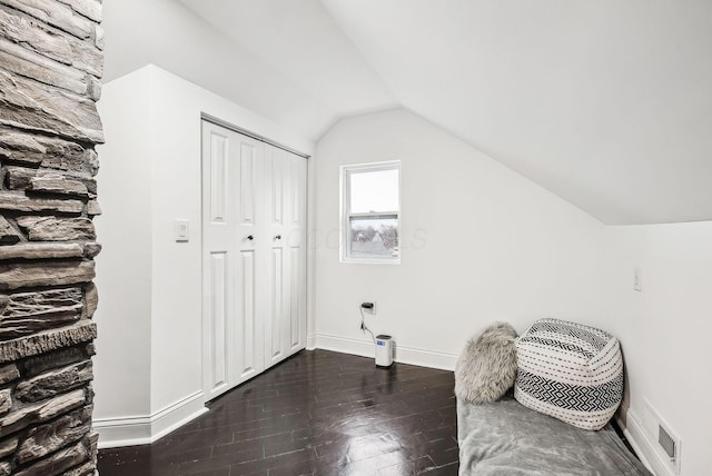 interior space with lofted ceiling, dark wood-style floors, visible vents, and baseboards