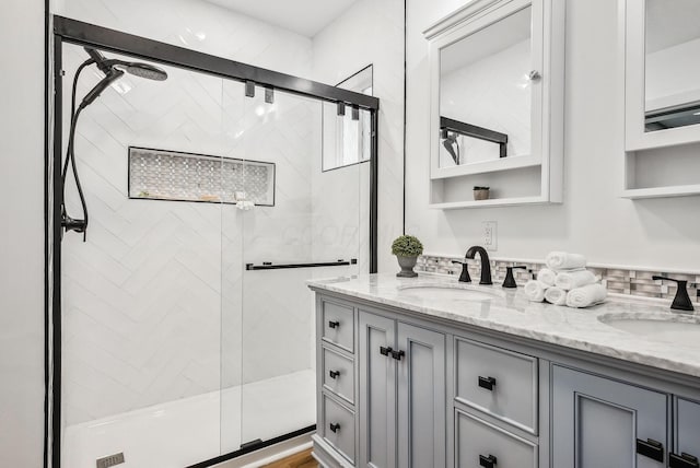 full bath featuring a shower stall, double vanity, and a sink