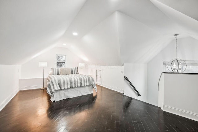 bedroom featuring a notable chandelier, vaulted ceiling, baseboards, and wood finished floors