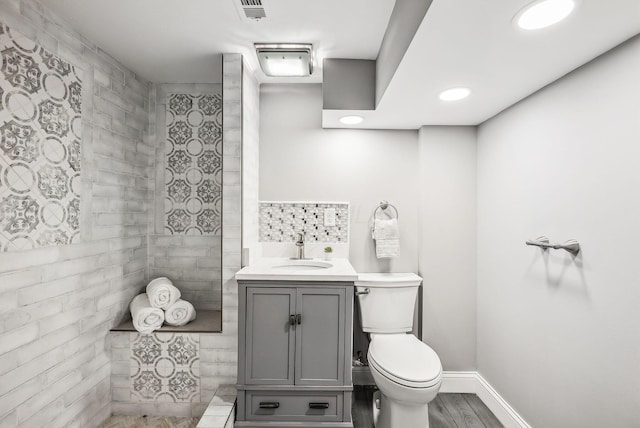 full bathroom with vanity, wood finished floors, visible vents, baseboards, and toilet