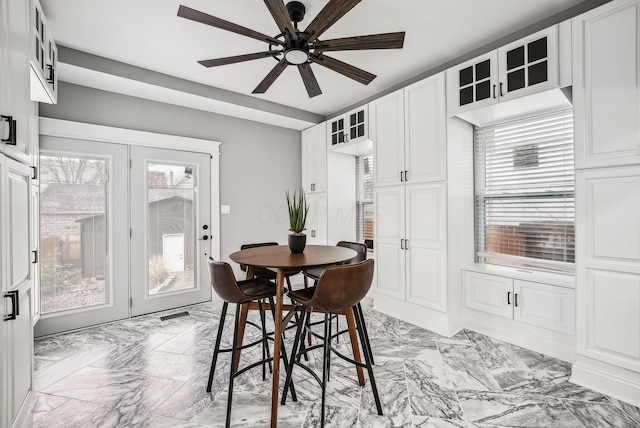 dining room with a wealth of natural light, marble finish floor, and a ceiling fan