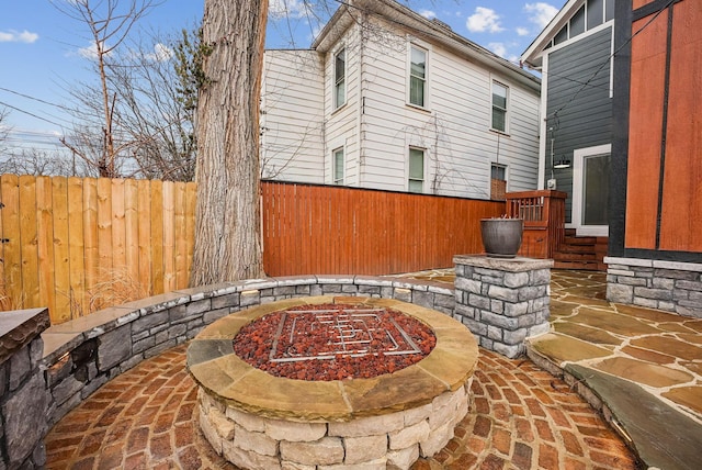 view of patio / terrace with an outdoor fire pit and fence