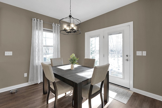 dining area featuring plenty of natural light, an inviting chandelier, baseboards, and wood finished floors