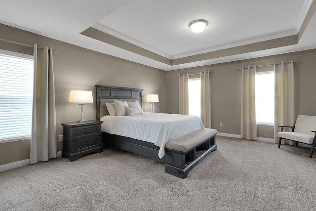 bedroom featuring baseboards, a raised ceiling, light carpet, and ornamental molding