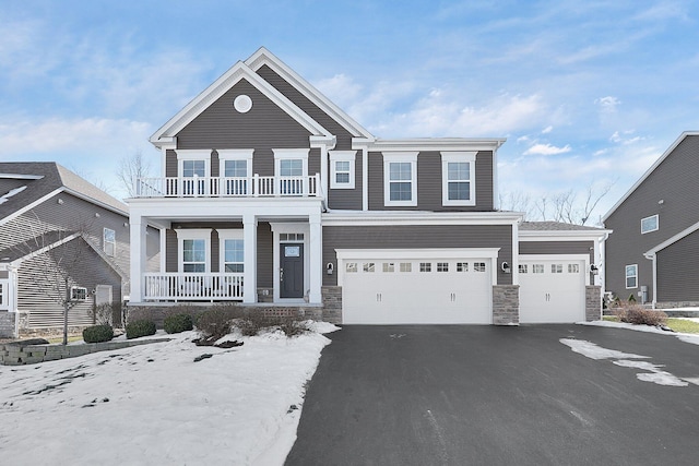 view of front of house with aphalt driveway, stone siding, a balcony, and covered porch