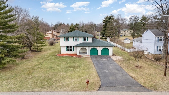 view of front facade with aphalt driveway, fence, a front yard, and stucco siding