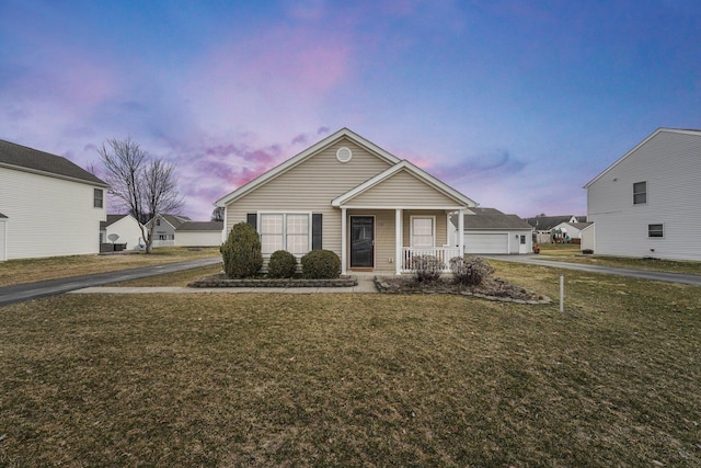 view of front of home with a garage, covered porch, an outdoor structure, and a front yard