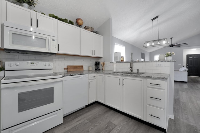 kitchen with a sink, tasteful backsplash, white appliances, a peninsula, and white cabinets