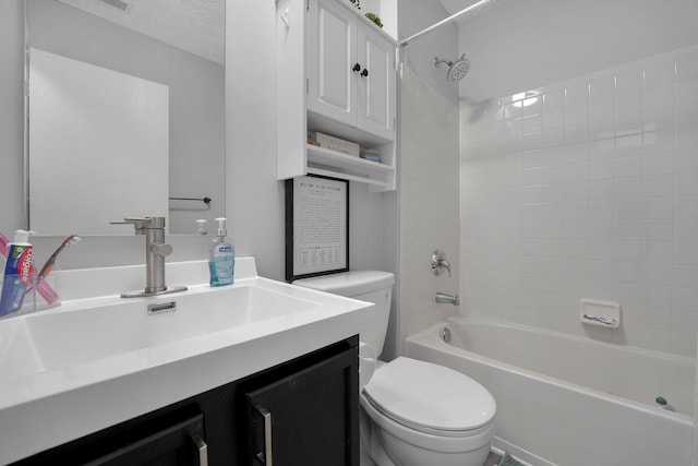 full bath featuring vanity, shower / bathing tub combination, toilet, and a textured ceiling