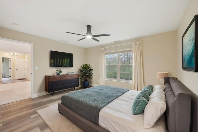 bedroom with baseboards, a ceiling fan, and wood finished floors