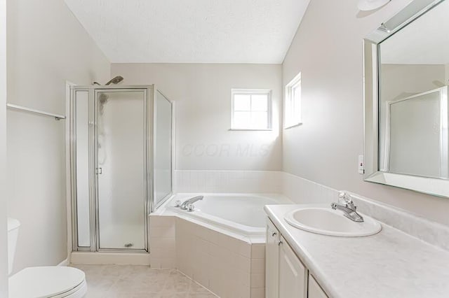 bathroom with a shower stall, toilet, vanity, a garden tub, and a textured ceiling