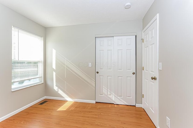 interior space with visible vents, light wood-style flooring, and baseboards