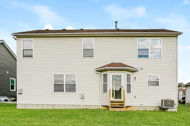 back of house featuring entry steps, a lawn, and central AC