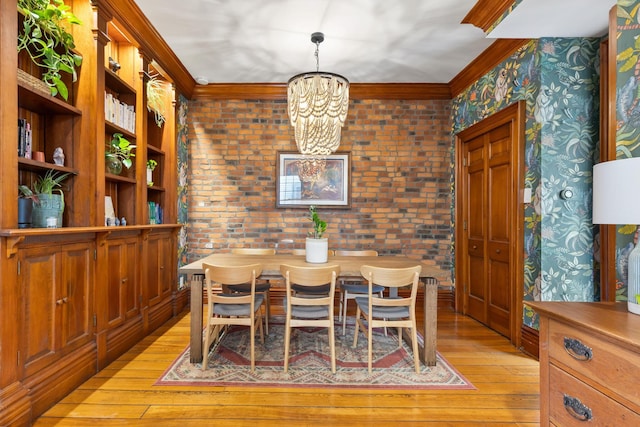 dining room featuring light wood-style flooring, a notable chandelier, and ornamental molding