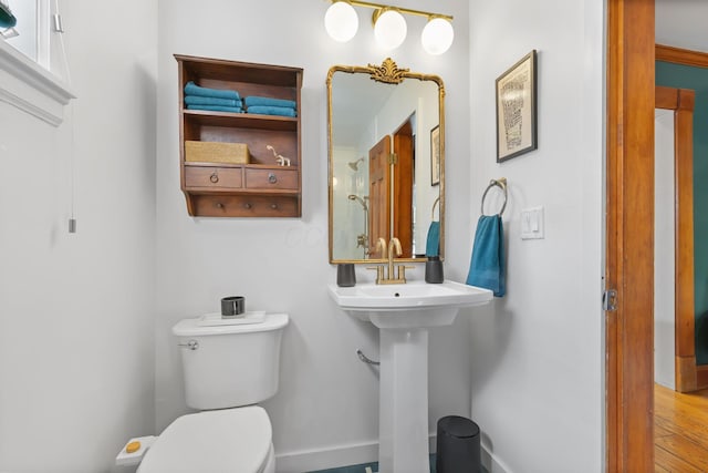 bathroom featuring toilet, wood finished floors, and baseboards