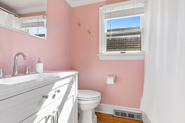 bathroom with vanity, wood finished floors, visible vents, baseboards, and toilet