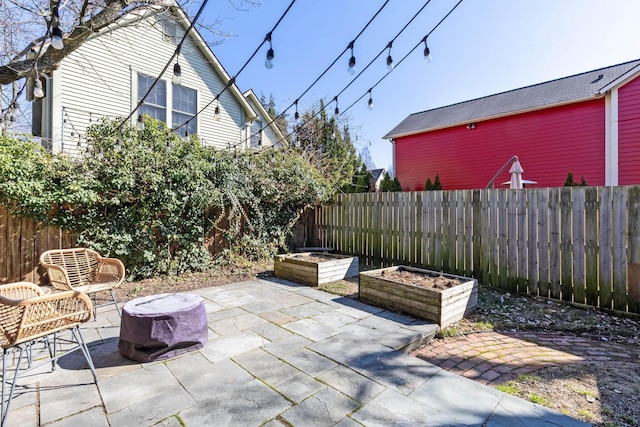 view of patio with a garden and a fenced backyard