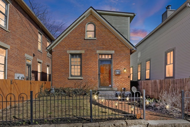 view of front of property with a fenced front yard and brick siding