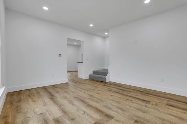 spare room with recessed lighting, stairs, baseboards, and wood finished floors