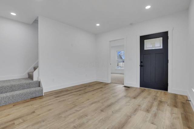 entryway featuring recessed lighting, baseboards, wood finished floors, and stairs