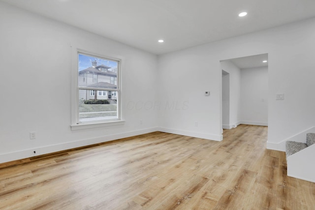 spare room featuring recessed lighting, stairway, baseboards, and light wood finished floors