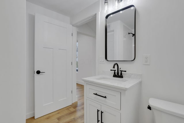 bathroom featuring vanity, toilet, and wood finished floors