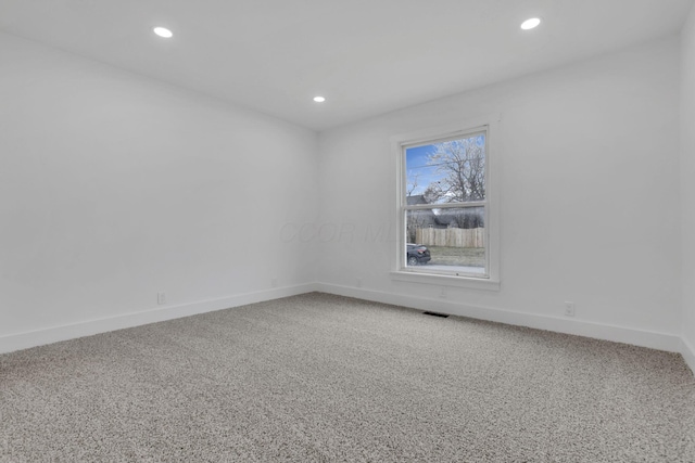 empty room featuring carpet flooring, recessed lighting, visible vents, and baseboards