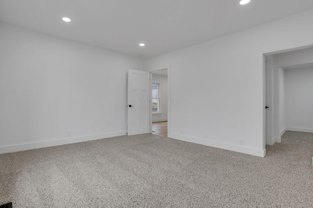 spare room featuring recessed lighting, baseboards, and light carpet