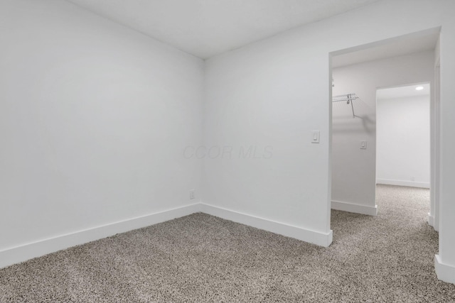 carpeted empty room with baseboards