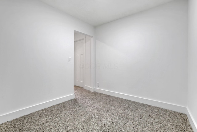 carpeted spare room with baseboards