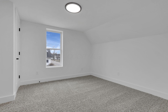 bonus room featuring lofted ceiling, carpet flooring, and baseboards