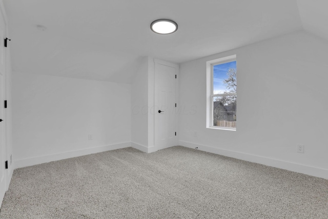 additional living space with vaulted ceiling, baseboards, and carpet floors